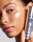 iS Clinical Daily Dynamic Hydrator – model holding the bottle with cream on her cheek