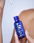 iS Clinical GeneXC Serum – bottle held in hand