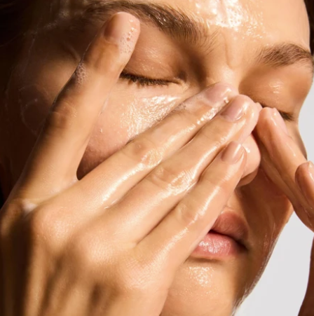 iS Clinical Cleansing Complex – model cleansing her face