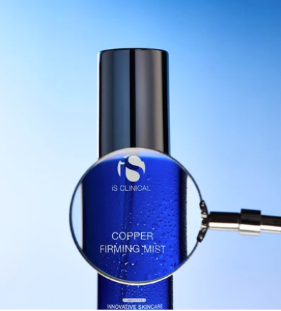 iS Clinical Copper Firming Mist – bottle under a magnifying glass