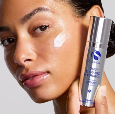 iS Clinical Daily Dynamic Hydrator – model holding the bottle with cream on her cheek